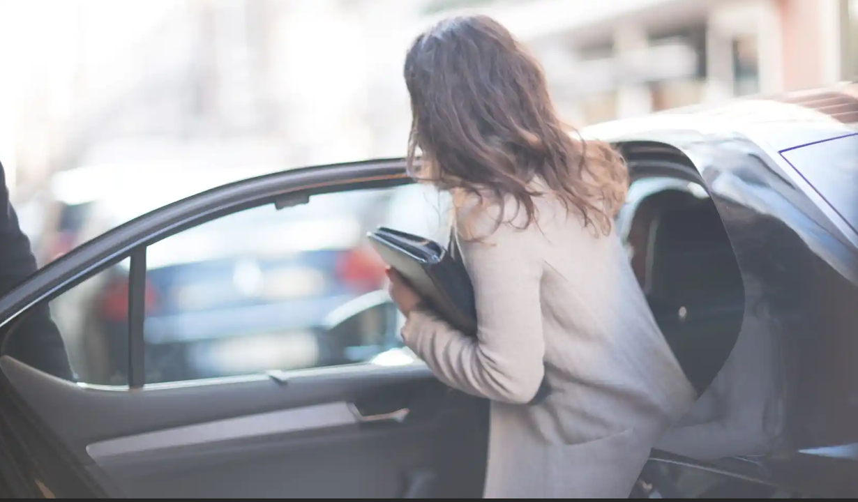 Vrouw die in een taxi stapt